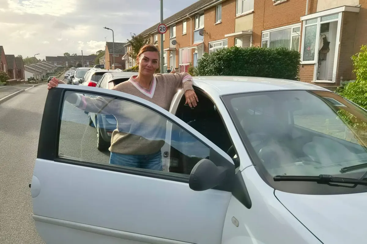 Rea Frame by her car on a residential street